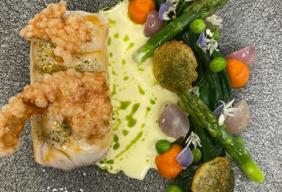 Charlie’s dish is a cod poached in lobster butter, lobster tapioca crisp, seasonal vegetables, pomme souffles, carrot puree and split butter sauce.