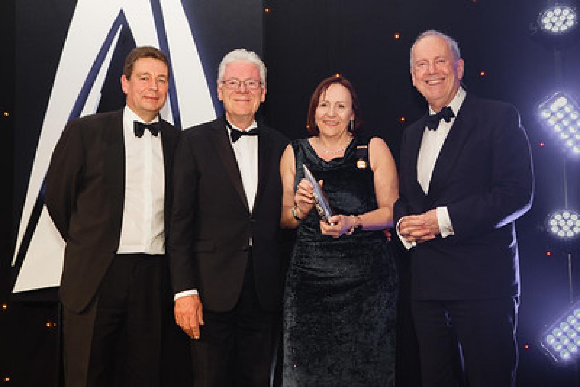 Julie Barker on stage with her award
