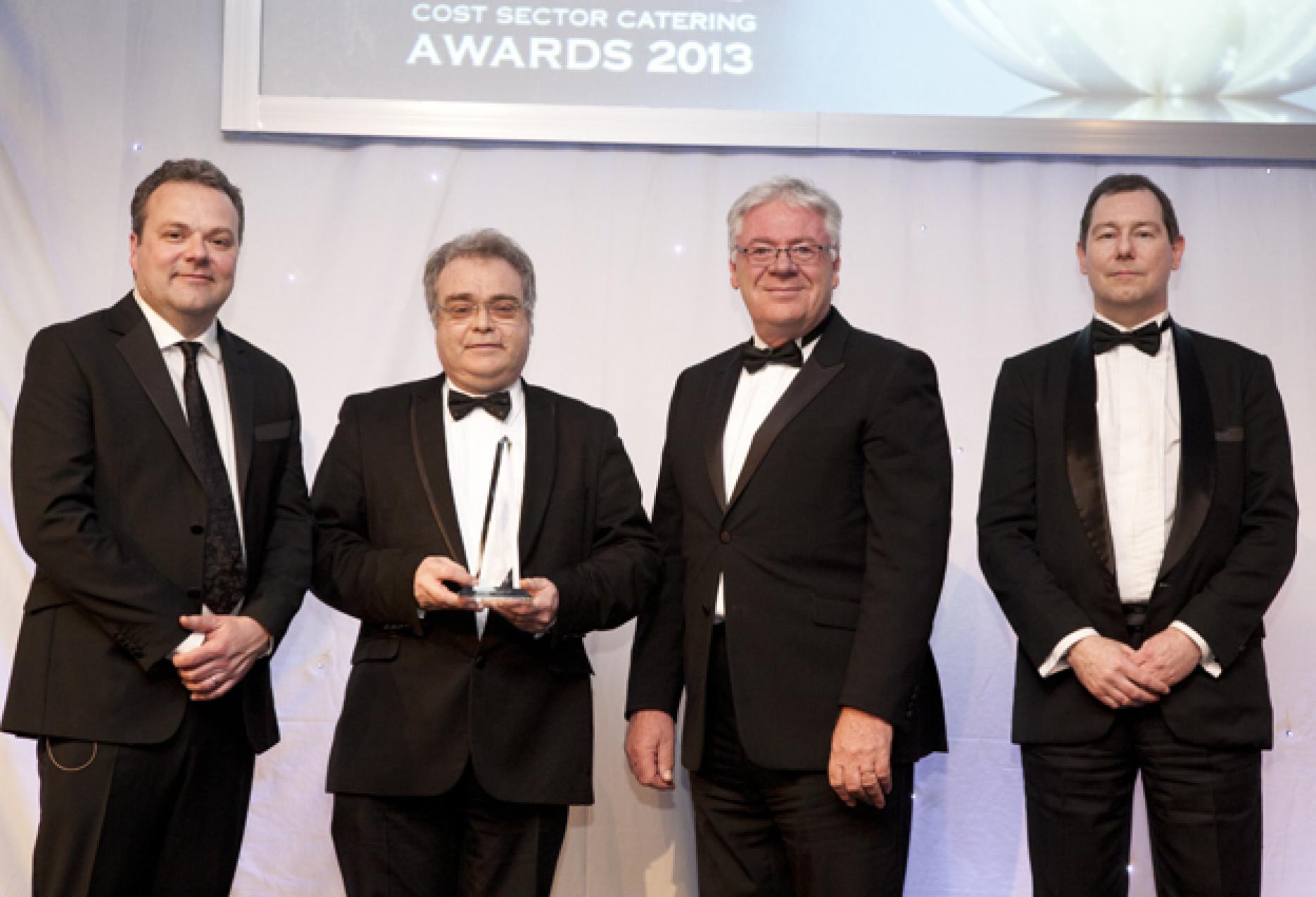 Public Sector Special Award winner David Foskett flanked by awards night host Hal Cruttenden, Roger Kellow of award sponsor Hobart and Cost Sector Catering editor David Foad